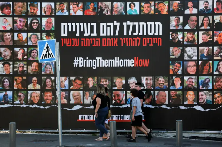 People walk past an installation which shows the pictures of hostages taken by Palestinian Islamist group Hamas following a deadly infiltration of Israel by Hamas gunmen from the Gaza Strip on October 7, before some of them are due to be released as part of a deal between Israel and Hamas to free hostages held in Gaza in exchange for the release of Palestinian prisoners, in Jerusalem, November 24, 2023 REUTERS/Ronen Zvulun