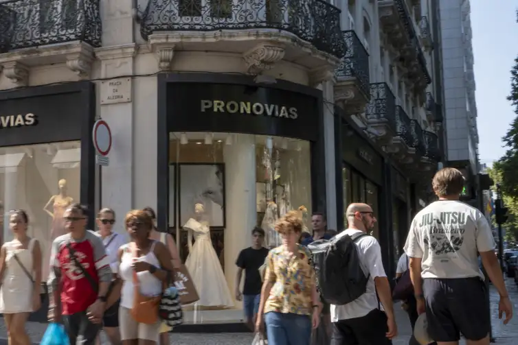 In Lisbon, Portugal, on August 2, 2025, people walk past a Pronovias storefront. The Spanish bridalwear company reports EUR135.9 million in revenue for 2023 and a net loss of EUR128.6 million. In early 2025, Pronovias reduces its capital by EUR193 million and appoints Cristina Alba Ochoa as CEO to lead a new turnaround strategy focused on international growth and financial stabilization by 2027. (Photo by Luis Boza/NurPhoto)NO USE FRANCE
